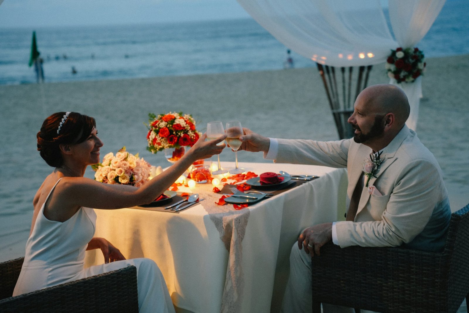 Couple toasting at a romantic beach dinner